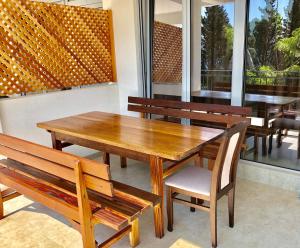 巴尔Apartmani Maja的餐厅设有木桌、椅子和窗户。