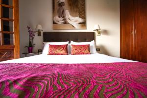 拉拉古纳Il Sogno di Gio della Laguna的一间卧室配有一张带粉色毯子的大床