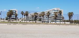 滨海罗克塔斯Residencial Mirador Playa Serena的一座白色的大建筑,前面有棕榈树