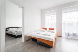 布达佩斯BpR CHIC White Home with Terrace & A/C & Garage的一间卧室设有两张床和两个窗户。