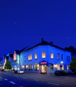 奥斯纳布吕克克鲁特酒店的夜晚街道边的蓝色建筑