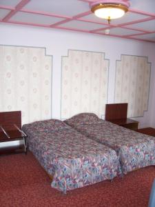 布鲁塞尔曼哈顿酒店的一间卧室设有一张床铺、一张桌子和天花板