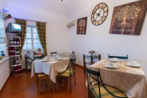 雷根古什-迪蒙萨拉什Hospedaria Os Condes的一间设有两张桌子和墙上一个时钟的餐厅