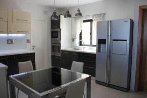 圣保罗湾城Sunny Lodge Apartment的厨房配有冰箱和桌椅