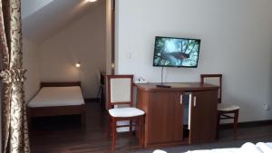 RychwałdApartamenty Panorama的客房设有桌子、椅子和电视。