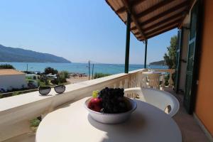 圣佐治欧斯帕贡House Dimitri Agios Georgios Pagoi Corfu的坐在阳台上桌子上的一碗水果