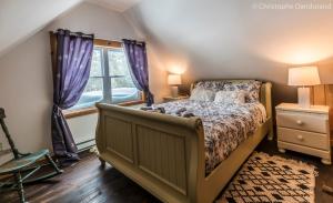 拉马巴耶Le Ross - Les Chalets Spa Canada的一间卧室设有一张床和一个窗口