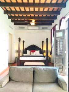 圣胡安圣胡安拉特拉扎酒店的一间卧室配有一张床和一个沙发