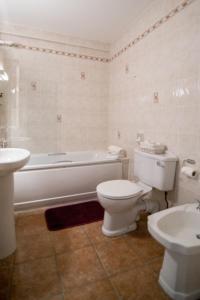 利敦瓦纳The Ritz House的浴室配有卫生间、浴缸和水槽。