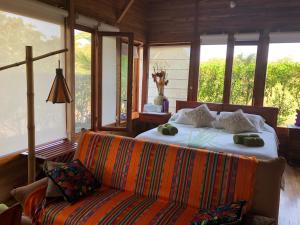 比亚米尔港切斯马纳加拉帕戈斯生态度假酒店的一间卧室配有一张床、一张沙发和窗户。