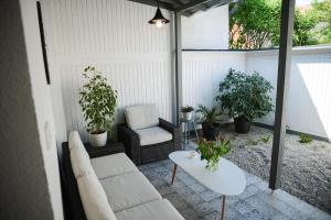 杰尔Rába Apartman House的天井配有沙发、桌子和植物