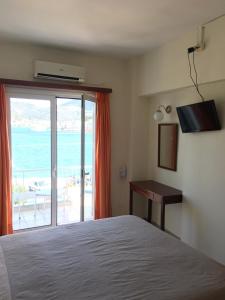 加拉塔斯Hotel Papasotiriou的一间卧室配有一张床,享有海景