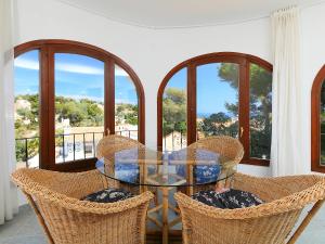 巴尔孔德马尔Holiday Home Balcon al Mar by Interhome的阳台配有玻璃桌子和椅子,设有窗户