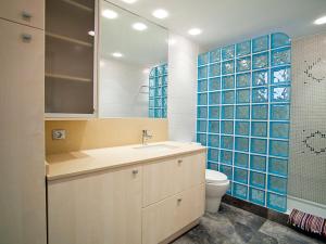 维拉福林Apartment DMS V by Interhome的浴室设有水槽、卫生间和蓝色瓷砖。
