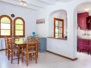 卡隆赫Holiday Home Cabanyes by Interhome的厨房配有红色橱柜和桌椅