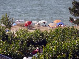 米尼奥Apartment Edificio Bahia II by Interhome的一群人在海滩上,带遮阳伞