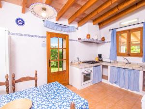 阿尔库迪亚Holiday Home Can Mateu by Interhome的厨房配有桌子和炉灶。 顶部烤箱
