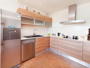 卡隆赫Holiday Home Mas Ambros by Interhome的厨房配有木制橱柜和不锈钢冰箱。