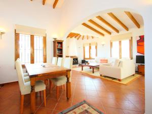 蒙特佩戈Holiday Home Del Azahar by Interhome的客厅配有木桌和白色椅子