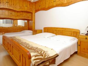 尼亚卢卡Apartment Šarenko-1 by Interhome的一间卧室设有两张带木墙和木橱柜的床。
