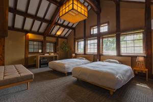 奈良NIPPONIA HOTEL NARA NARAMACHI的一间卧室设有两张床、一张沙发和窗户。