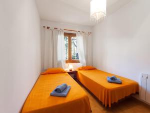 卡隆赫Holiday Home Sansu by Interhome的配有橙色床单的客房内的两张床