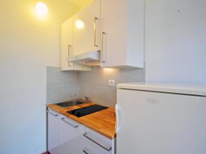 乌马格Holiday Home Aron by Interhome的厨房配有白色橱柜和木制台面