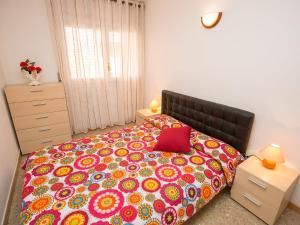 滨海托萨Apartment Rambla de Tossa by Interhome的一间卧室配有一张大床和彩色床罩