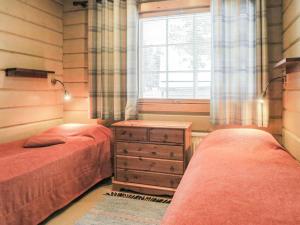 列维奥特乐维奥图度假屋的一间卧室设有两张床、一个窗口和一个梳妆台。