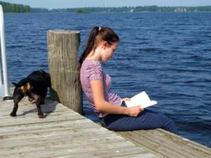 伊萨尔米克罗考罗度假屋的坐在码头上读着一本书的女孩