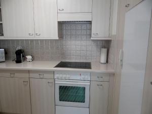 英格堡Apartment Blumenweg 2 by Interhome的厨房配有白色橱柜和炉灶烤箱。
