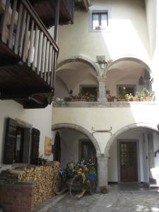 阿尔塔泰尔梅Sot I Volz - locazione turistica的一座带拱门的建筑和一座鲜花阳台