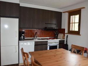 伦克Apartment Brandegg 4 by Interhome的一间带木桌的厨房和一间带炉灶的厨房