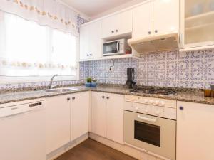 维拉福林Apartment DMS IV-3 by Interhome的厨房配有白色橱柜、水槽和微波炉