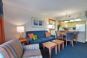 德斯坦Bay Club of Sandestin, a VRI resort的一间带蓝色沙发的客厅和一间厨房