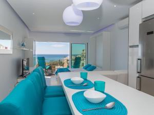 阿尔布费拉Studio Dream View 50m from the beach by Interhome的厨房以及带桌子和蓝色椅子的客厅。