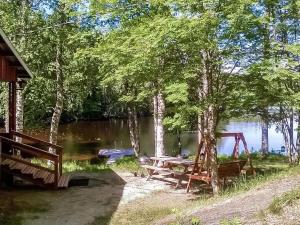 SavonrantaHoliday Home 2235 by Interhome的湖畔的野餐桌,树木繁茂
