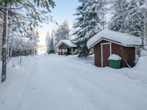SavonrantaHoliday Home Villa kontio by Interhome的雪覆盖的路上的雪覆盖小屋
