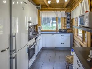 HerttualaHoliday Home Leporanta by Interhome的一间厨房,配有白色家电和木制天花板