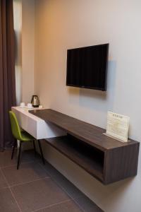 独鲁万Hotel Costa Brava的墙上有电视的房间里一张桌子