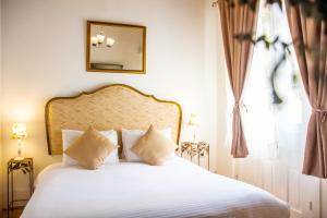 卡塔赫纳Hotel Casa la Tablada的一间卧室配有一张带白色床单和镜子的床