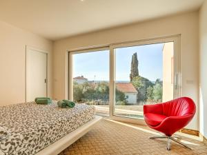 洛雷茨卡Apartment Karmen by Interhome的卧室设有红色椅子和大窗户