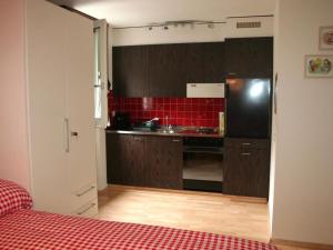 英格堡Apartment Sörenweg 5 by Interhome的厨房配有黑色冰箱和红色瓷砖
