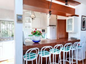 卡隆赫Holiday Home Mirador by Interhome的厨房配有白色橱柜和带凳子的台面