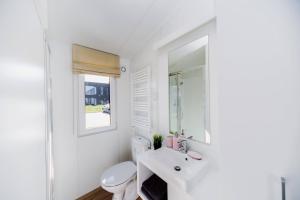 约灵City Camping Hjørring的白色的浴室设有水槽和卫生间。