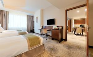 麦加Holiday Suites Al Azizia的酒店客房配有两张床和一张书桌