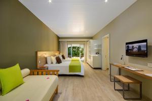 格兰贝伊Mauricia Beachcomber Resort & Spa的配有一张床和一张书桌的酒店客房