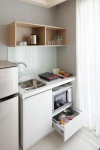 台北晴美公寓酒店的白色的厨房配有水槽和微波炉