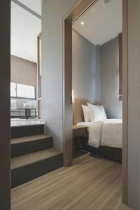 台北晴美公寓酒店的一间卧室配有一张床,楼梯通往一间客房