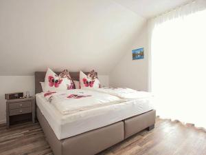 布莱特瑙Ferienhaus am Rösslewald的卧室配有带粉红色枕头的大型白色床